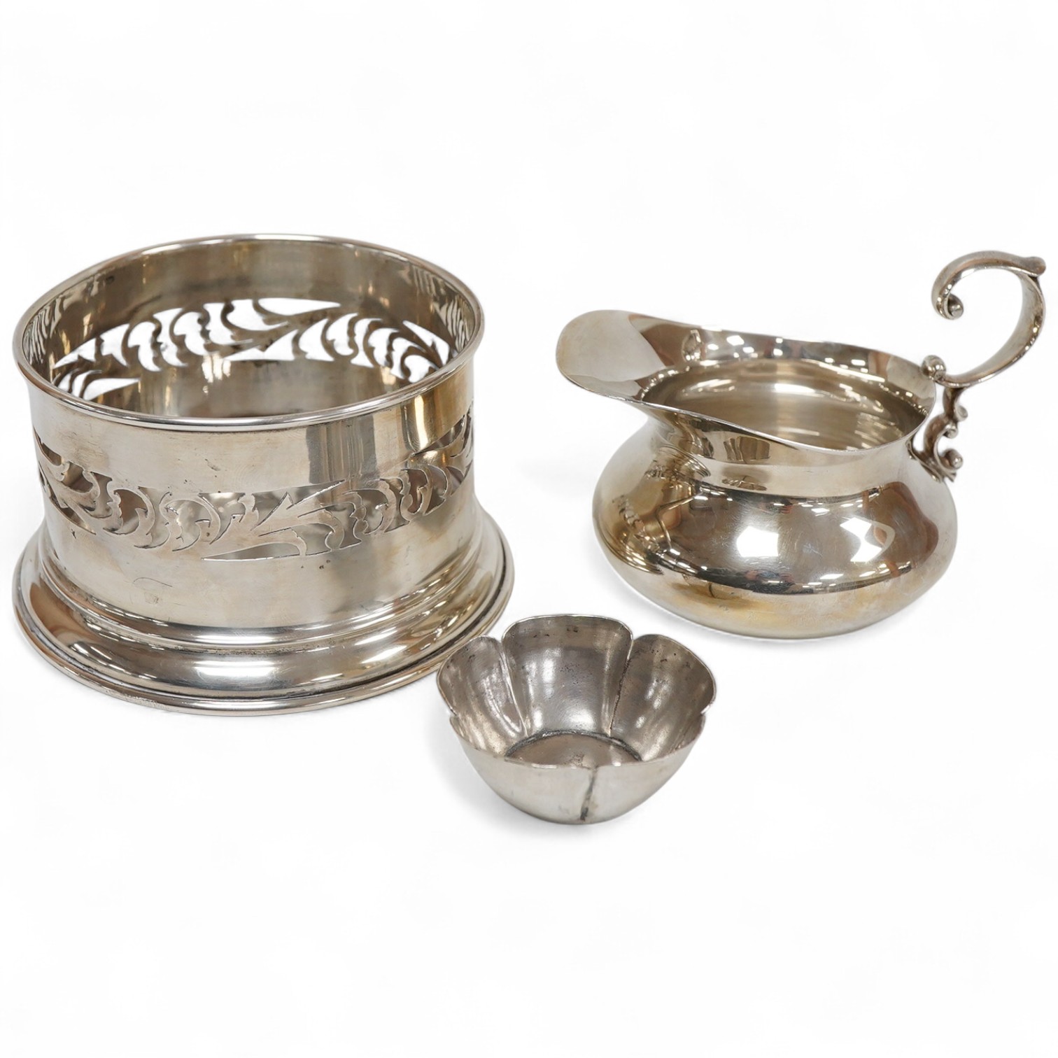 An Italian pierced 900 standard white metal bottle coaster, diameter 99mm, together with a sterling cream jug and a small 925 bowl, 9.9oz.